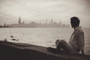 young adult sitting on wall
