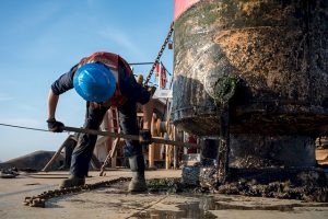 man cleaning buoy