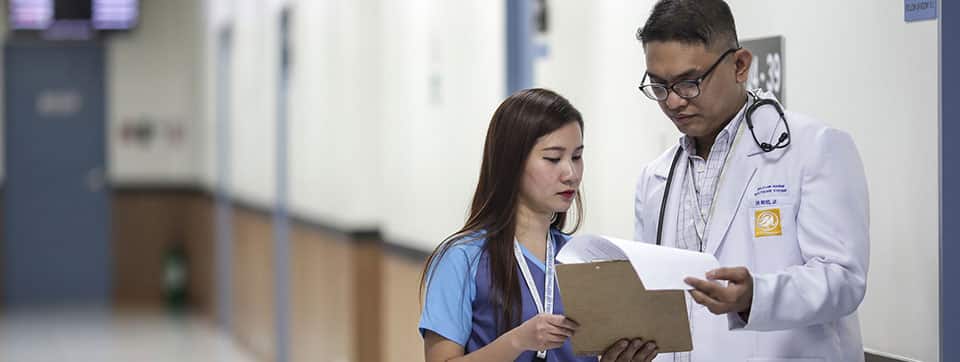 doctor and his nurse looking over chart