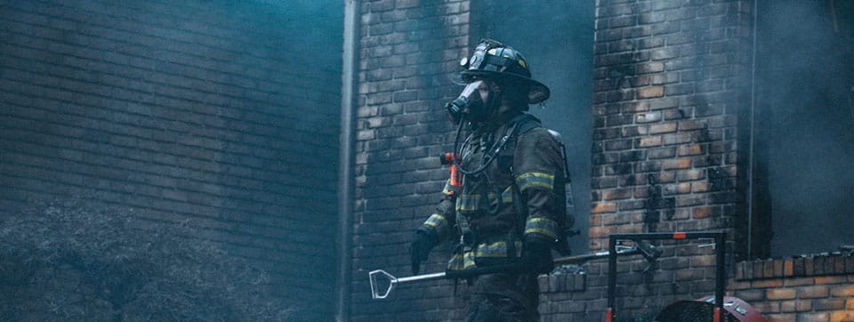 firefighter at a burned building site